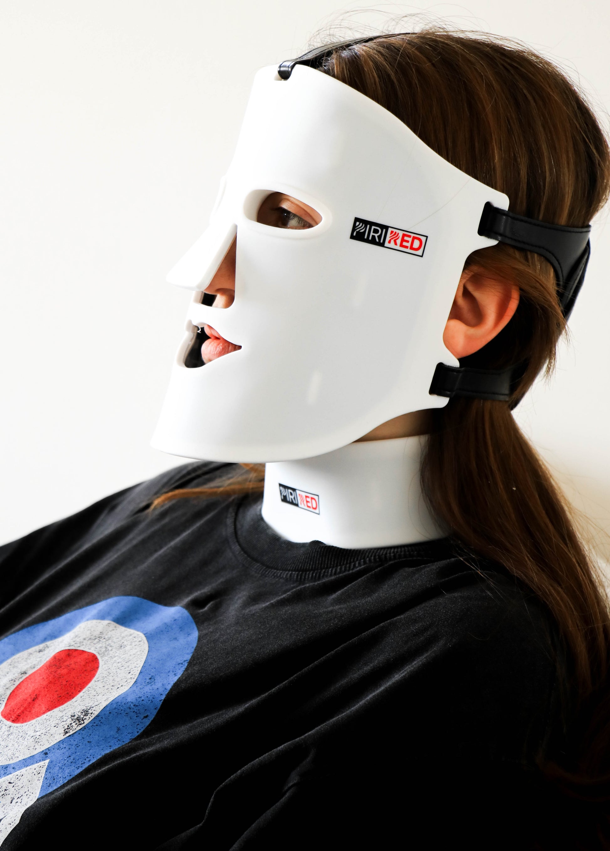 woman wearing red light therapy mask and its neck piece